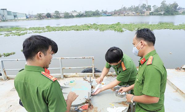 Công an đang tiến hành niêm phong khoang chứa xăng dầu tại điểm phá án trên sông Hậu. Ảnh Công an Đồng Nai cung cấp.