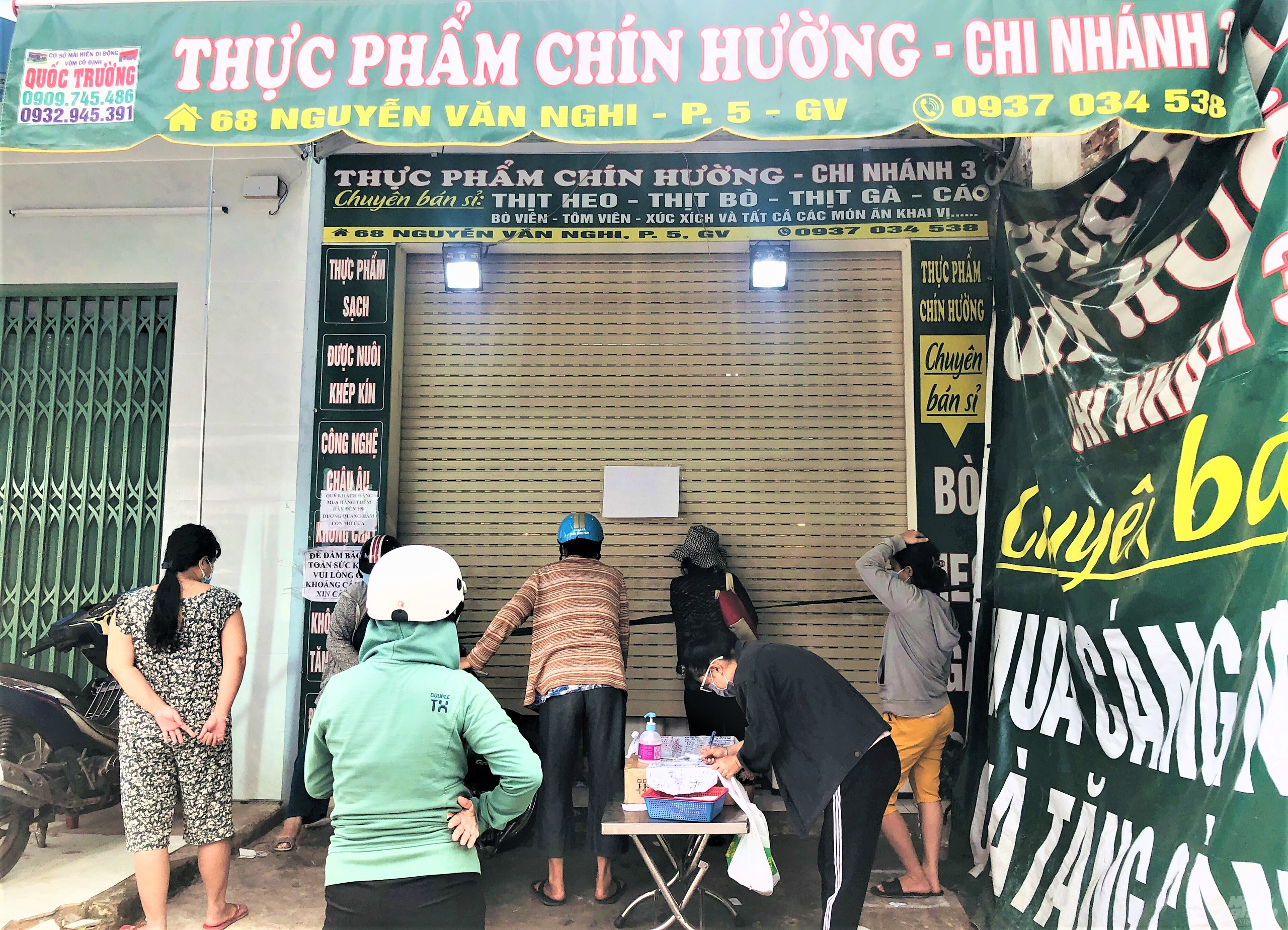 Vì lượng hàng thực phẩm hạn chế nên cửa hàng thực phẩm trên đường Nguyễn Văn Nghi chỉ mở hé cửa giao dịch với khách. Ảnh: Minh Sáng.