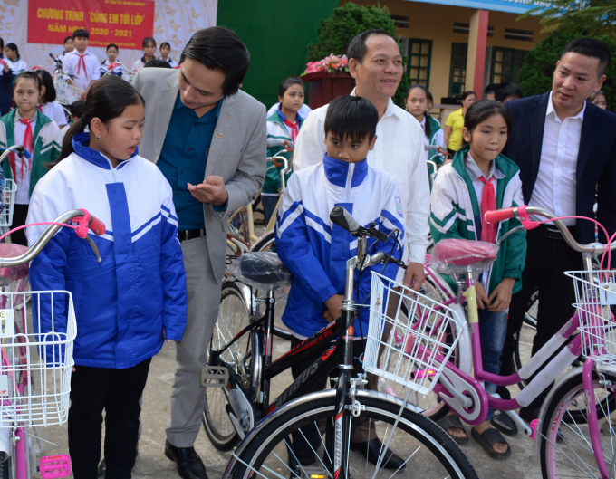 Nhà báo Vũ Minh Việt - Phó TBT báo NNVN (thứ hai trái sang), ông Triệu Tiến Thịnh - Chủ tịch Hội Khuyến học tỉnh Yên Bái (thứ 4 trái sang) ông Vũ Ngọc Hà - Đại diện Quỹ Thiện Tâm (thứ nhất bên phải) trao xe đạp cho các em. Ảnh: Thái Sinh.