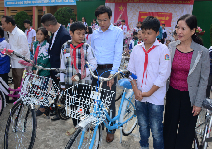 Thầy giáo Lê Minh Đức - Phó GĐ Sở Giáo dục - Đào tạo (thứ 3 phải sang) cùng lãnh đạo Hội Khuyến học trao xe đạp và dặn dò các em. Ảnh: Thái Sinh. 