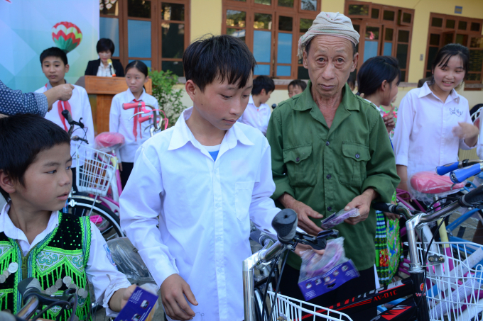 Bố em Giàng A Mang ngỡ ngàng khi nhận xe cho con. Ảnh: Thái Sinh.