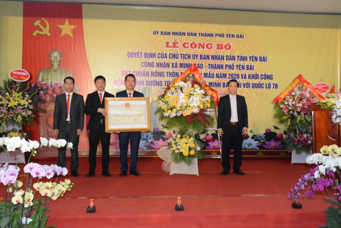 Ông Nguyễn Đức Điển- PGĐ Sở NN-PTNT tỉnh Yên Bái (phải) trao chứng nhận và tặng hoa cho lãnh đạo xã Minh Bảo. Ảnh: Thái Sinh.