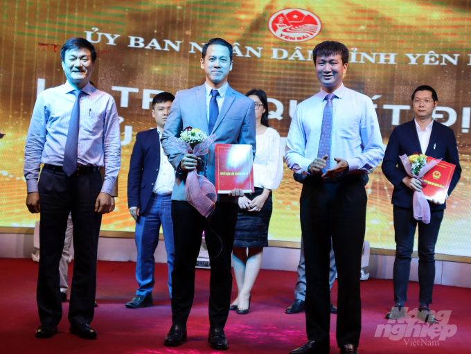 Ông Trần Huy Tuấn - Chủ tịch tỉnh Yên Bái (phải) cùng ông Nguyễn Chiến Thắng - Phó Chủ tịch tỉnh Yên Bái (trái) trao Quyết định chủ trương đầu tư và tặng hoa cho nhà đầu tư Nhật Bản (giữa). Ảnh: Thái Sinh.