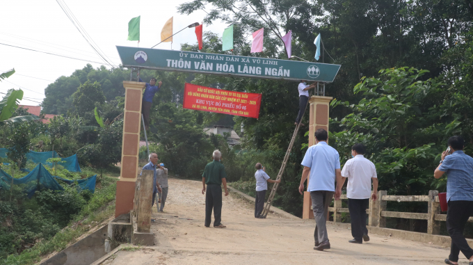 Các thành viên trong tổ bầu cử thôn Làng Ngần đang treo biển điểm bầu cử cho người dân biết. Ảnh: Thái Sinh.