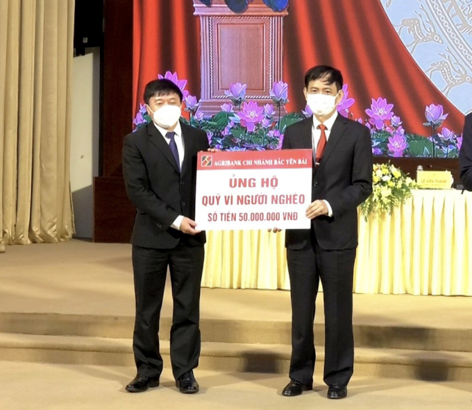 Ông Nguyễn Mạnh Hồng, Giám đốc Chi nhánh Agribank Bắc Yên Bái (phải) trao 50 triệu ủng hộ quỹ vì người nghèo tỉnh Yên Bái. Ảnh: CTCC.
