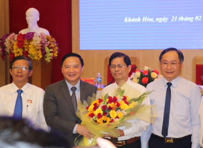Ông Nguyễn Tấn Tuân (thứ 2 từ phải sang) nhận hoa chúc mừng từ Bí thư Tỉnh ủy Khánh Hòa Nguyễn Khắc Định. Ảnh Kim Sơ.