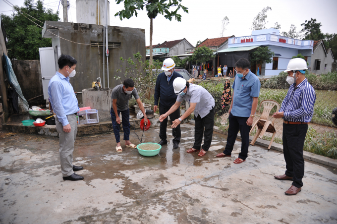 Ông Trần Quang Hoài, Tổng cục Trưởng Tổng Cục phòng chống thiên tai, Phó Trưởng Ban Chỉ đạo Quốc gia về phòng chống thiên tai kiểm tra nguồn nước sinh hoạt của người dân huyện Phú Hòa sau mưa lũ. Ảnh: AN.