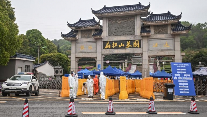 Người mặc trang phục bảo hộ đứng bên ngoài nghĩa trang Biandanshan, Vũ Hán. Ảnh: Getty Images.