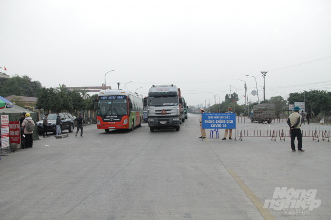Chốt kiểm soát liên ngành làm nhiệm vụ 24/7 tại cầu Đá Bạc, Quốc lộ 10, TP Uông Bí (Quảng Ninh) có rất nhiều xe cơ giới, container và người dân đến khai báo y tế.