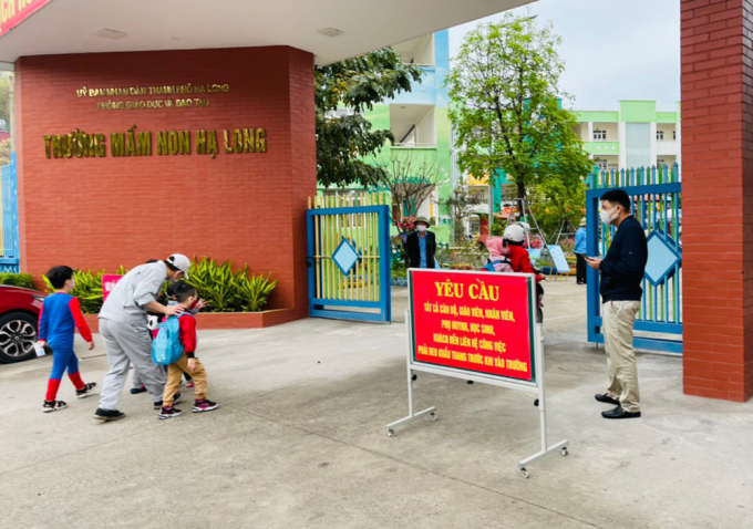 Phụ huynh và trẻ đeo khẩu trang khi tới một trường mầm non ở TP Hạ Long (Quảng Ninh). Ảnh: CTV.