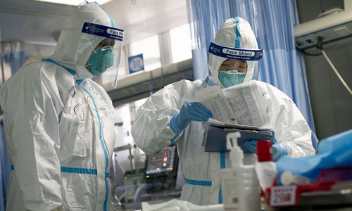 Một nhân viên y tế cùng đồng nghiệp kiểm tra hồ sơ chẩn đoán của một bệnh nhân tại Bệnh viện Trung Nam của Đại học Vũ Hán ở Vũ Hán, trung tâm tỉnh Hồ Bắc (Trung Quốc). Ảnh: Tân Hoa Xã.