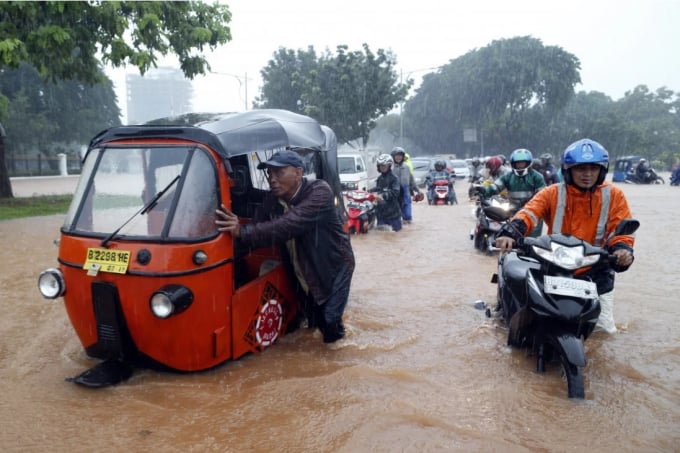 Những người Indonesia đẩy xe của mình qua vùng nước lũ ở Jakarta năm 2015. Ảnh: EPA.