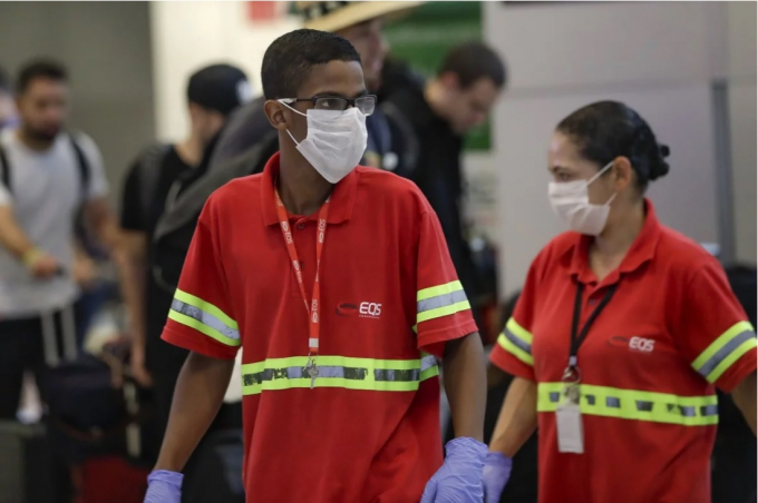 Nhân viên sân bay quốc tế Sao Paulo Brazil đeo khẩu trang trong khi làm việc để đề phòng virus lây lan. Ảnh: AP.