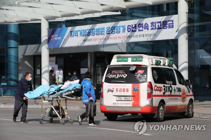 Một bệnh nhân được chuyển từ Trung tâm Y tế Seoul ở Seoul đến một bệnh viện khác vào ngày 27 tháng 2 năm 2020, sau khi trung tâm được chỉ định là Bệnh viện chỉ điều trị Covid-19. Ảnh: Yonhap.