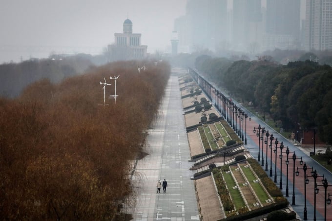 Hai cư dân đi bộ trong công viên Jiangtan không một bóng người ở Vũ Hán (Trung Quốc). Ảnh: Stringer/Getty Images.
