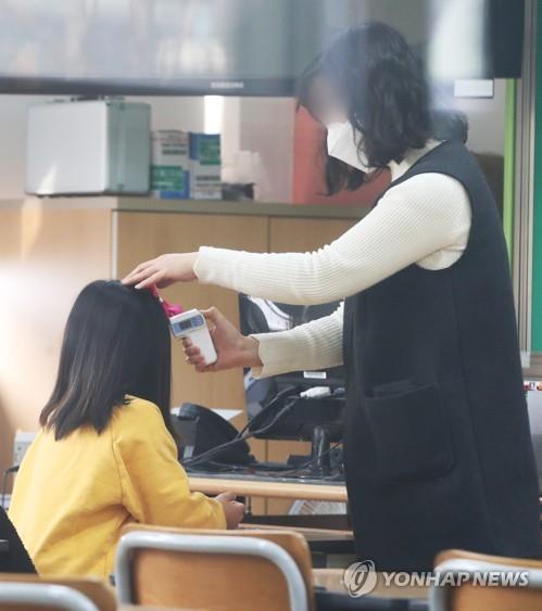 Một học sinh trường tiểu học ở Suwon, ngay phía nam Seoul, được đo thân nhiệt. Ảnh: Yonhap.
