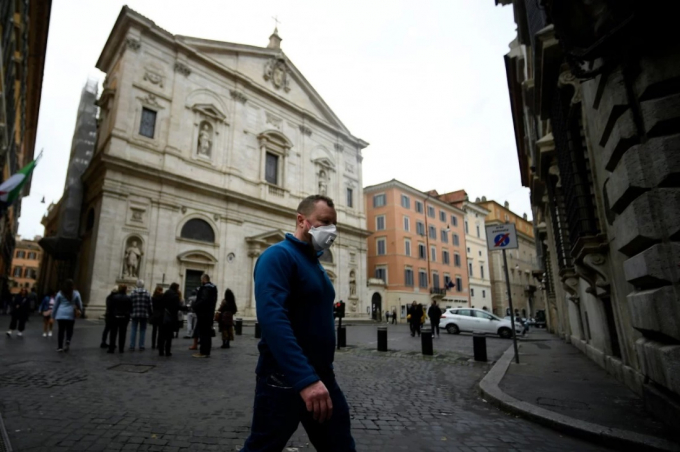 Người đàn ông đeo khẩu trang đi ngang qua Nhà thờ St. Louis của người Pháp ở Rome. Ảnh: AFP.