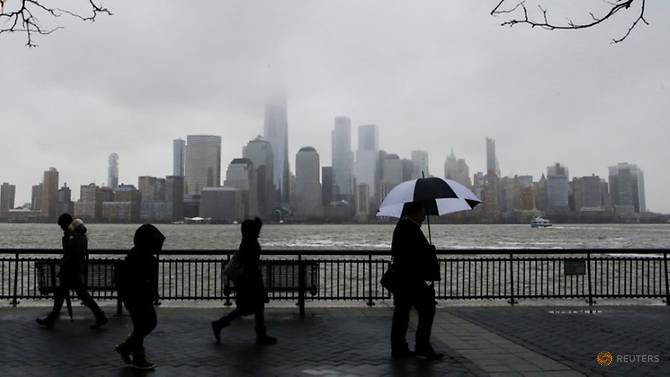 Những người New York đi bộ trong mưa. Ảnh: Eduardo Munoz/Reuters.