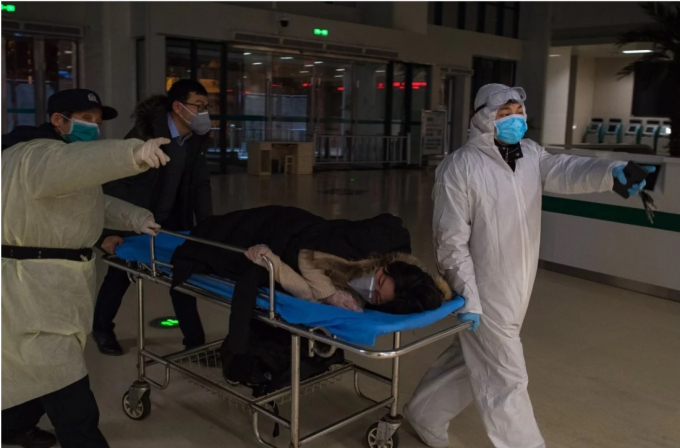 Các tình nguyện viên đưa một phụ nữ mang thai vào Bệnh viện Sức khỏe Bà mẹ và Trẻ em Vũ Hán để xét nghiệm virus Corona. Ảnh: Tân Hoa Xã.