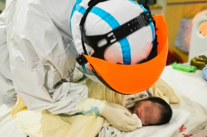 Bác sĩ chăm sóc cho một trẻ sơ sinh có mẹ bị Covid-19 tại một bệnh viện ở tỉnh Hồ Bắc. Em bé không có dấu hiệu nhiễm virus. Ảnh: Tân Hoa Xã.