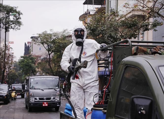 Lực lượng bộ đội hóa học triển khai phun hóa chất tiêu tẩy khu vực phố Châu Long, quận Ba Đình. Ảnh: Dương Giang/TTXVN.