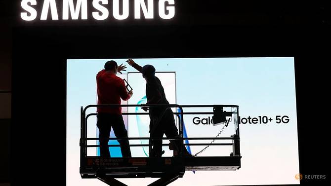 Hai công nhân lắp đặt một màn hình Samsung trong sảnh của Trung tâm Hội nghị Las Vegas để chuẩn bị cho CES 2020 ở Las Vegas, Nevada, Hoa Kỳ. Ảnh: Steve Marcus/Reuters.