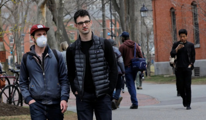 Một sinh viên đeo khẩu trang khi đi ngang qua khuôn viên trường Đại học Harvard hôm 10/3/2020. Ảnh: Reuters.