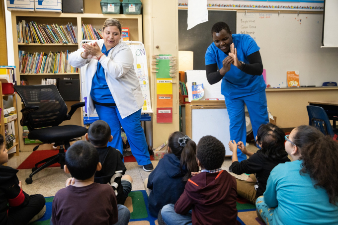 Thực tập sinh y tế Soledad Lupian (trái) và Edwin Gituma hướng dẫn các học sinh lớp hai Trường tiểu học Ethel Phillips ở Sacramento về cách rửa tay đúng cách nhằm ngăn ngừa virus lây lan. Ảnh: Max Whittaker/New York Times.