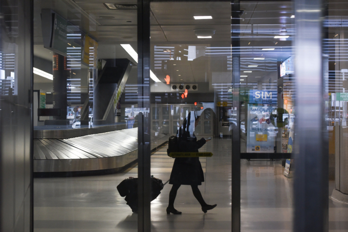 Một người phụ nữ đi ngang qua băng chuyền hành lý tại sân bay quốc tế Kennedy ở New York. Lệnh giới hạn các chuyến bay từ châu Âu do Tổng thống Trump công bố có hiệu lực vào ngày 14/3. Ảnh: Stephanie Keith/New York Times.