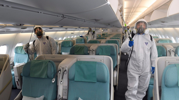 Nhân viên y tế mặc đồ bảo hộ phun thuốc khử trùng bên trong máy bay để đề phòng nCoV tại sân bay quốc tế Incheon, Hàn Quốc, hôm 4/3/2020. Ảnh: Suh Myoung-geon/Yonhap.