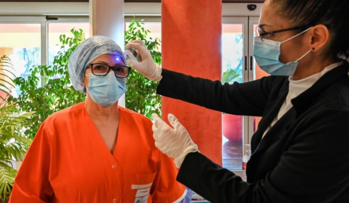 Một y tá được kiểm tra thân nhiệt tại phòng chăm sóc đặc biệt tại bệnh viện Casal Palocco gần Rome. Ảnh: AFP.