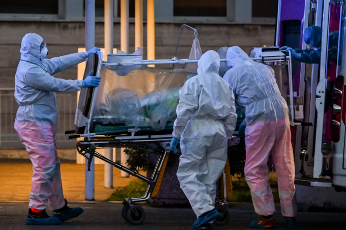Nhân viên y tế mặc đồ bảo hộ đưa một bệnh nhân được chăm sóc đặc biệt vào bệnh viện dã chiến Columbus Covid 2 mới được xây dựng ở Bệnh viện Gemelli (Rome) hôm 16/3/2020. Ảnh: Andreas Solaro/AFP.