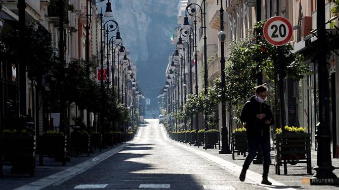 Người đàn ông đeo khẩu trang bước đi trên đường phố bị phong tỏa ở Sorrento. Ảnh: Ciro De Luca/Reuters.