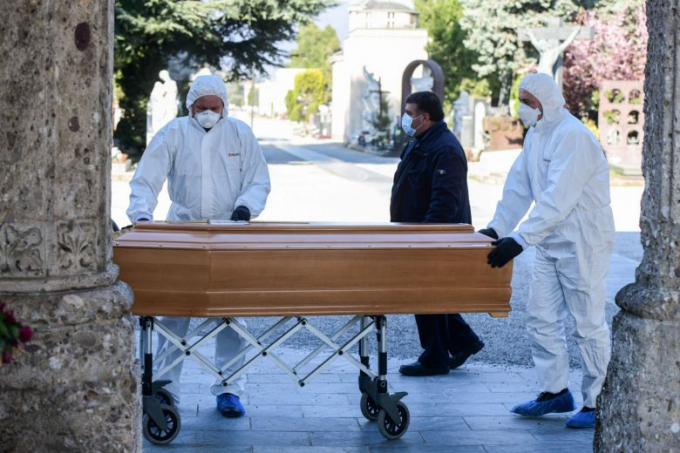 Những người mặc đồ bảo hộ và đeo khẩu trang vận chuyển quan tài của một bệnh nhân Covid-19 tại Italia. Ảnh: AFP.