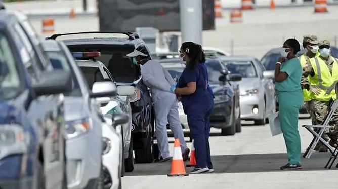 Nhân viên y tế kiểm tra hành khách trên xe tại Sân vận động Hard Rock ở Miami Gardens (Florida). Ảnh: Wilfredo Lee/AP.