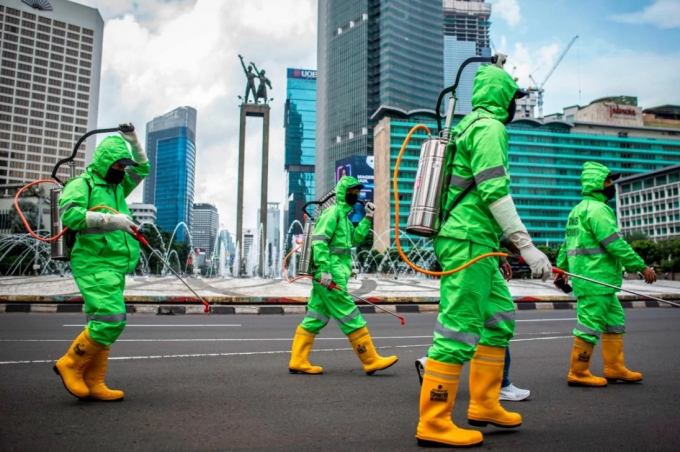 Nhân viên y tế phun thuốc khử trùng ở Jakarta, Indonesia hôm 22/3/2020. Ảnh: Reuters.