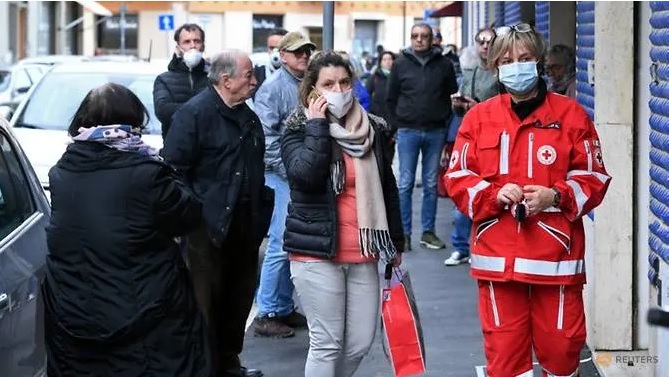 Mọi người chờ được phát khẩu trang tự chế miễn phí bên ngoài một cửa hàng gia đình Italia, tại thành phố Grosseto, Tuscan. Ảnh: Jennifer Lorenzini/Reuters.