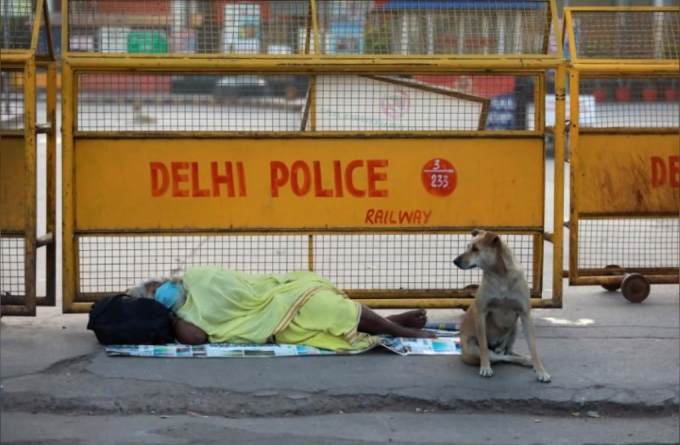 Một người vô gia cư nằm trên vỉa hè ngoài ga đường sắt.