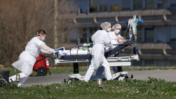 Một bệnh nhân mắc Covid-19 được sơ tán khỏi bệnh viện dân sự Mulhouse, miền Đông nước Pháp, hôm 23/3/2020. Vùng Grand Est hiện là tâm dịch ở Pháp, nơi số ca tử vong vì Covid-19 cao thứ ba ở châu Âu, chỉ sau Italia và Tây Ban Nha. Ảnh: Jean-Francois Badias/AP.