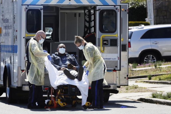 Kỹ thuật viên y tế khẩn cấp (EMT) nâng một bệnh nhân được xác định mắc Covid-19 lên xe cứu thương tại thành phố New York hôm 26/3/2020. Ảnh: Stefan Jeremiah/Reuters.