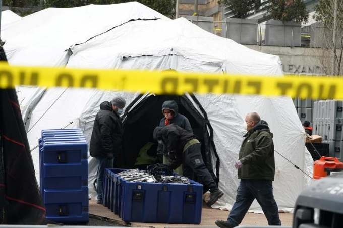 Các công nhân được nhìn thấy bên ngoài một khu lều dã chiến bị coi là nhà xác tạm thời tại New York. Ảnh: Reuters.