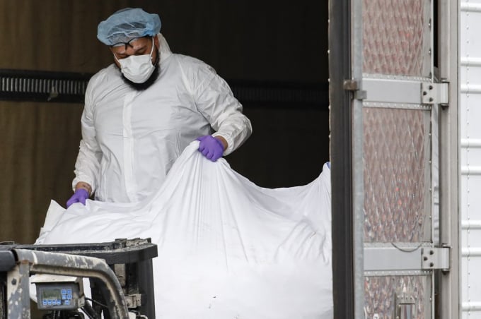 Một thi thể nạn nhân Covid-19 bọc trong nhựa được chất lên xe container lạnh sử dụng làm nhà xác tạm thời hôm 31/3/2020, tại Trung tâm Bệnh viện Brooklyn, quận Brooklyn, New York. Ảnh: John Minchillo/AP.