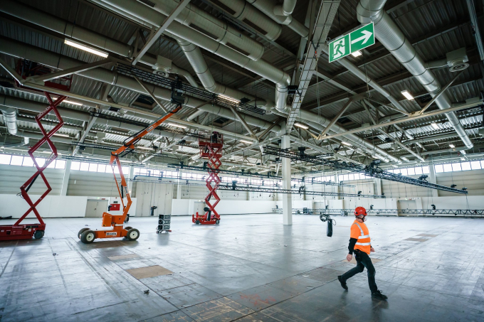 Công nhân xây dựng cải tạo một phòng triển lãm ở Berlin thành bệnh viện dã chiến điều trị cho bệnh nhân Covid-19. Ảnh: Shutterstock.