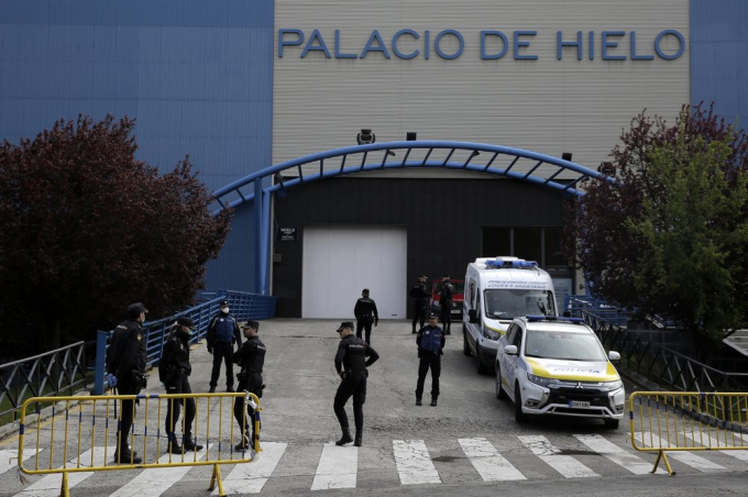 Các sĩ quan cảnh sát đứng trước sân băng của Madrid (Tây Ban Nha), bị cải tạo thành một nhà xác tạm thời, hôm 24/3/2020. Ảnh: Manu Fernandez/AP.