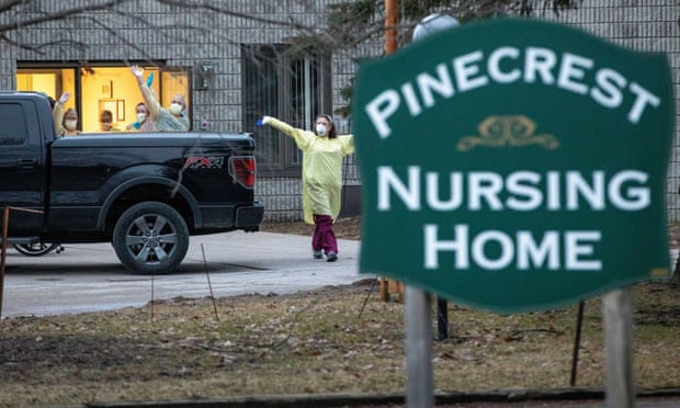 Nhân viên tại viện dưỡng lão Pinecrest ở Bobcaygeon, Ontario, vẫy tay chào những chiếc xe cứu trợ. Ảnh: Carlos Osorio/Reuters.