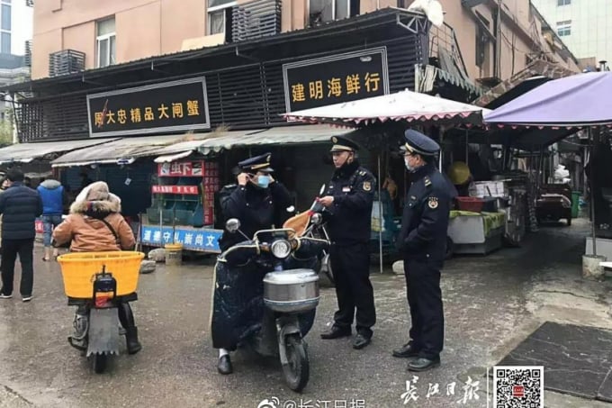 Các nhân viên thực thi pháp luật đứng bảo vệ bên ngoài chợ hải sản ở Vũ Hán được lệnh đóng cửa sau khi dịch cúm bí ẩn bùng phát. Ảnh: Dương Tử hàng ngày.