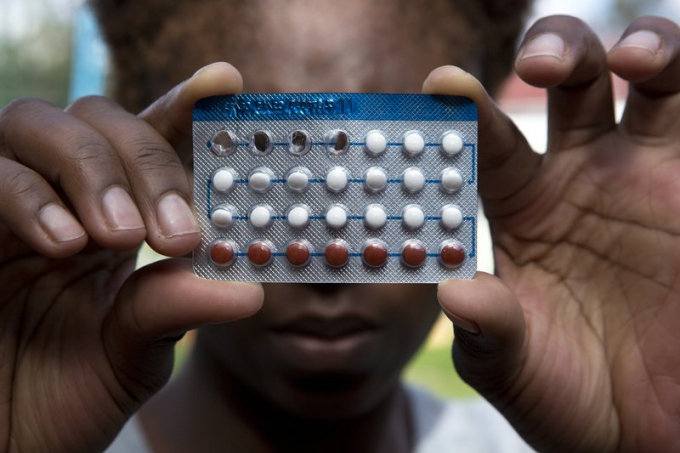 Một phụ nữ cầm vỉ thuốc tránh thai, ở Harare, Zimbabwe, ngày 9/4/2020. Ảnh: Tsvangirayi Mukwazhi/AP.