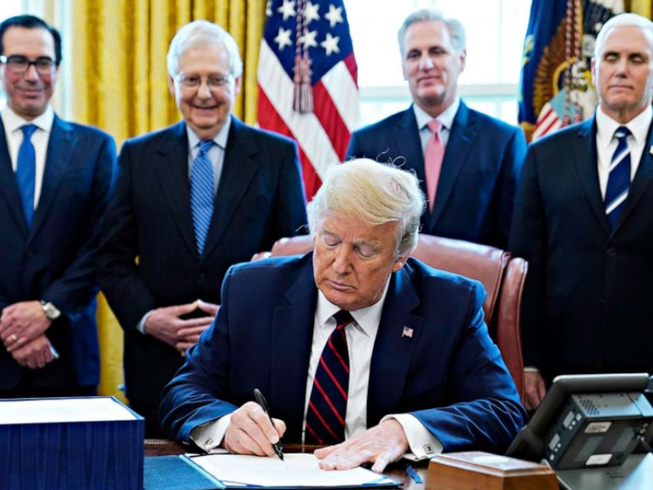Tổng thống Donald Trump ký ban hành gói giải cứu lịch sử trị giá 2.200 tỉ USD ngay sau khi Quốc hội thông qua, ngày 27/3/2020. Ảnh: ABCNEWS.
