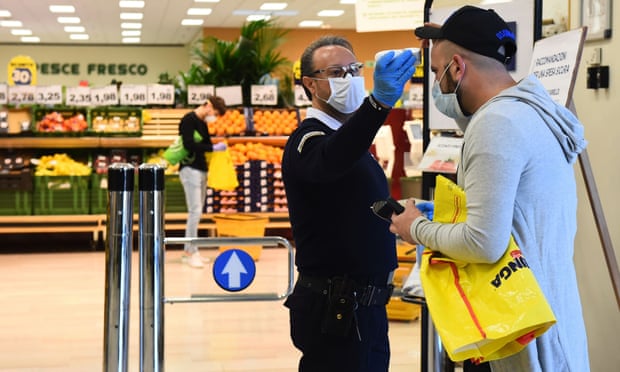 Khách hàng được đo nhiệt độ tại lối vào của một siêu thị ở Torino, Italia. Ảnh: Massimo Pinca/Reuters.