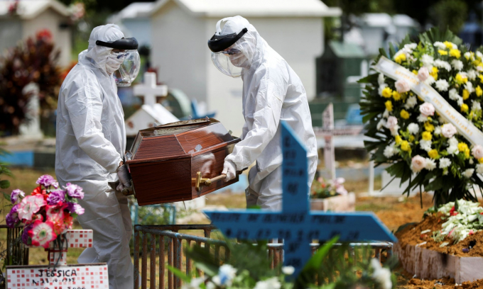 Nhân viên nhà tang lễ Brazil mặc đồ bảo hộ vận chuyển quan tài của một nạn nhân Covid-19. Ảnh: Reuters.